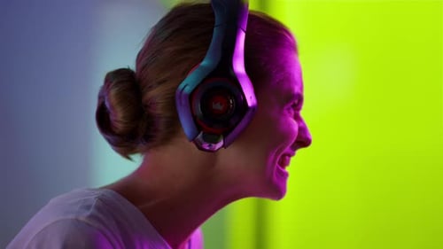 Young Adult Wearing Headphones Smiling in Colorful Room
