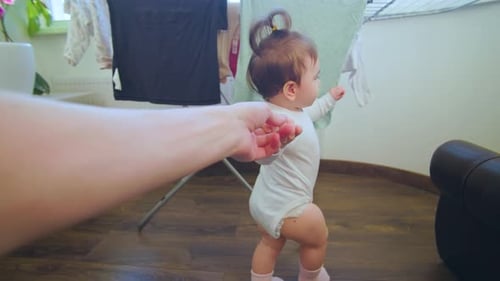 Pov Shot of a Baby First Steps of Baby Learning to Walk at Home Helped By the Mother