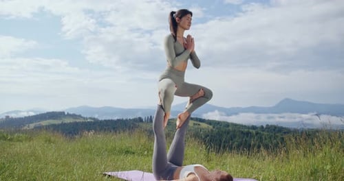 Two Women Doing Acroyoga in Scenic Countryside