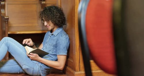 Man reading a book in the library 4k