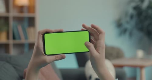 Man Using Smartphone with Chroma Key Screen on Couch