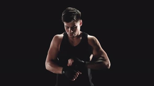 Young Man Wrapping Hands with Boxing Wraps
