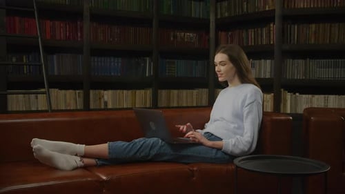Woman Lying on Couch Waving During Video Call