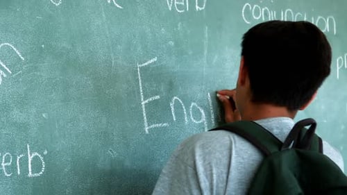 Student Writes English Grammar on Chalkboard in Classroom