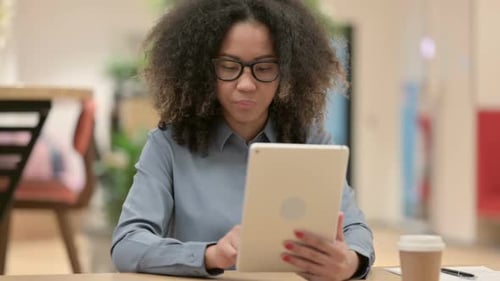 Young Adult Using Tablet at Desk in Office