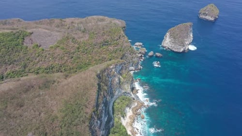Luftaufnahme von Rocky Cliff Mountains und funkelndem Meerwasser am Strand, Indonesien
