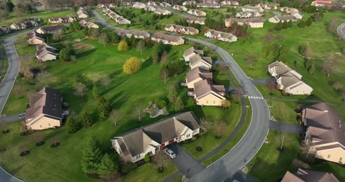 Homes in American neighborhood community development. Aerial of tan brown houses, road and walking p