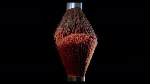 Dos pinceles de maquillaje con polvo sobre fondo negro con concepto de pintura a cámara lenta a la luz del sol. V2