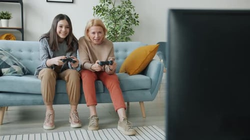 Teen Girl and Senior Woman Playing Video Game