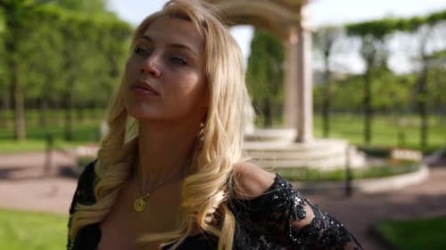 Portrait of a Blonde with Big Breasts and in a Black Dress