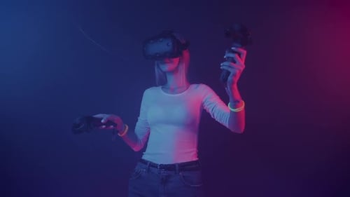 Young Girl Gamer Wearing Virtual Reality Glasses Playing Game, Holding and Moving Joystick