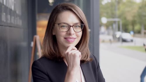 Confident Woman Smiling Outside in Urban Setting
