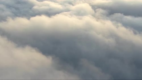 Flying Over the Clouds and Mountain Peaks with a View To the Sea After Sunset