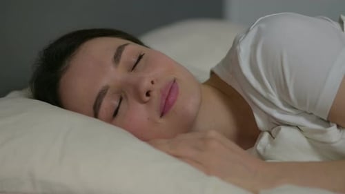 Woman Sleeping Peacefully on a Bed at Home