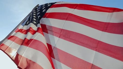 American Flag Waving Proudly Against Clear Blue Sky