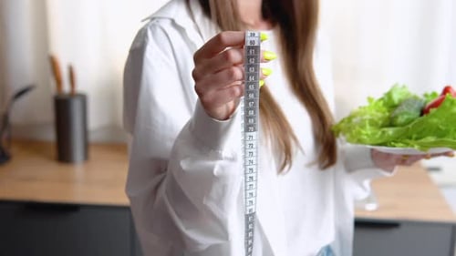 Woman with Salad Measuring with Ruler Indoors