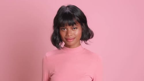 Smiling Young Woman with Wavy Hair in Studio