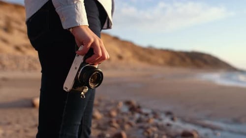 Photographer Holding Slr Camera On Beach