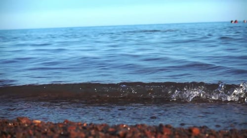 Meereswellen rollen am Kiesstrand