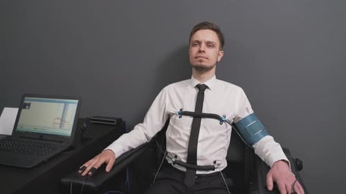 Bearded Man Passing Check on Polygraph Machine in Office