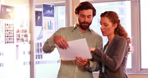 Business Colleagues Reviewing Documents in Modern Office