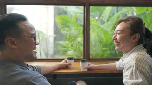 4K Asian man and woman meeting and talking together at coffee shop