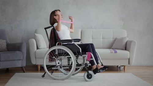 Woman in Wheelchair Exercises with Resistance Band