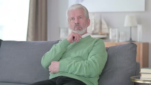 Serious Old Man Sitting at Home and Thinking