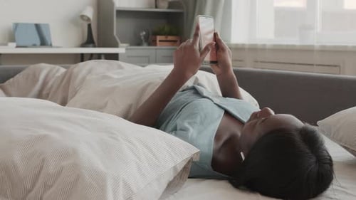 Woman Relaxing in Bed with Smartphone