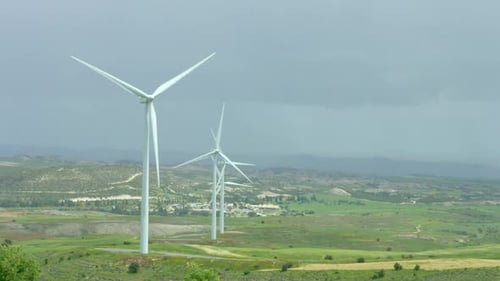 Wunderschöne Landschaft mit grünen Hügeln und rotierenden Windrädern, grüne Energie