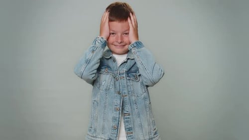 Young Boy Poses Against Gray Background