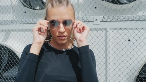 Stylish Woman Posing in Front of Metal Fence