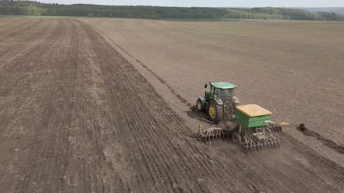 Tractor Plows Soil in Rural Farm Field