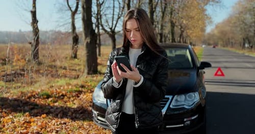 Woman Uses Phone Near Broken Down Car