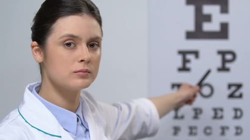 Woman Doctor Points to Eye Exam Chart