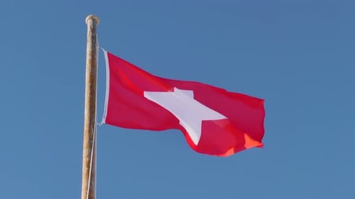 Swiss Flag Waving Against a Clear Blue Sky