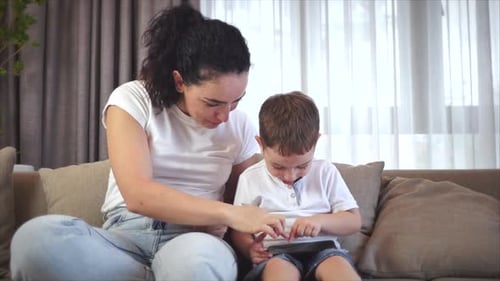 Woman and Child Enjoying Tablet Together Indoors