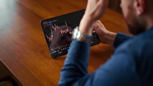 Young Adult Watching Tablet with Stock Chart