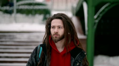 Hipster is Walking in City in Snowy Winter Day Young Peaceful Citizen in European Town