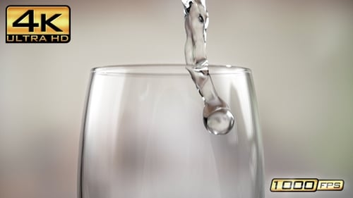 Water pouring into clear glass close-up