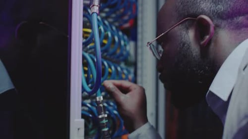 IT Professional Inspecting Cables Inside Server Room