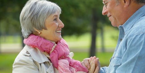 Senior Couple Enjoying a Walk Hand-in-Hand in Park