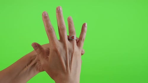 Woman Puts on Ring Against Green Screen