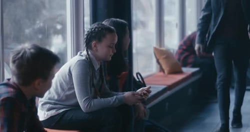 Students Using Smartphone in School Corridor