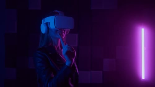 Woman Using Virtual Reality Headset in Neon Lit Room