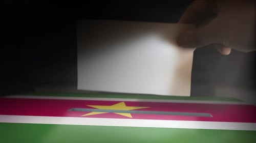 Hand Casting Vote In Suriname Ballot Box