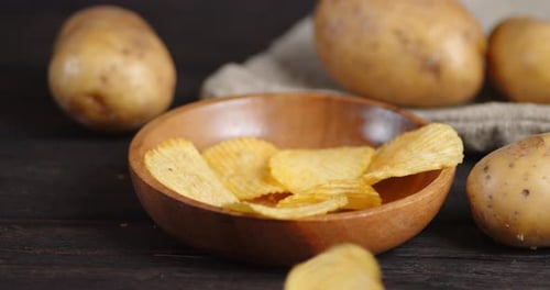 Potato Chips Falling into Wooden Bowl Still Life