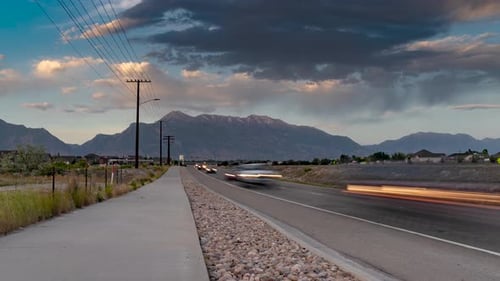 Gewitterwolken über den Bergen, während der Verkehr entlang der Autobahn fließt - verkleinern Zeitraffer