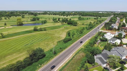 Aerial View of Cars Driving Next to Golf Course