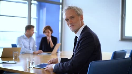 Confident Man Using Tablet in Meeting